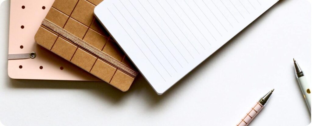 Cuadernos de notas junto a bolígrafos
