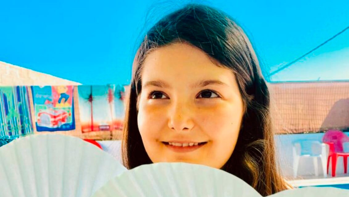 Niña en una zona de piscina con abanicos
