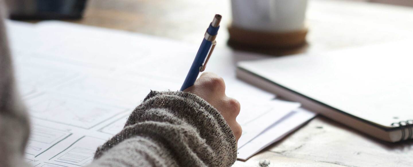 Persona redactando documentos a mano